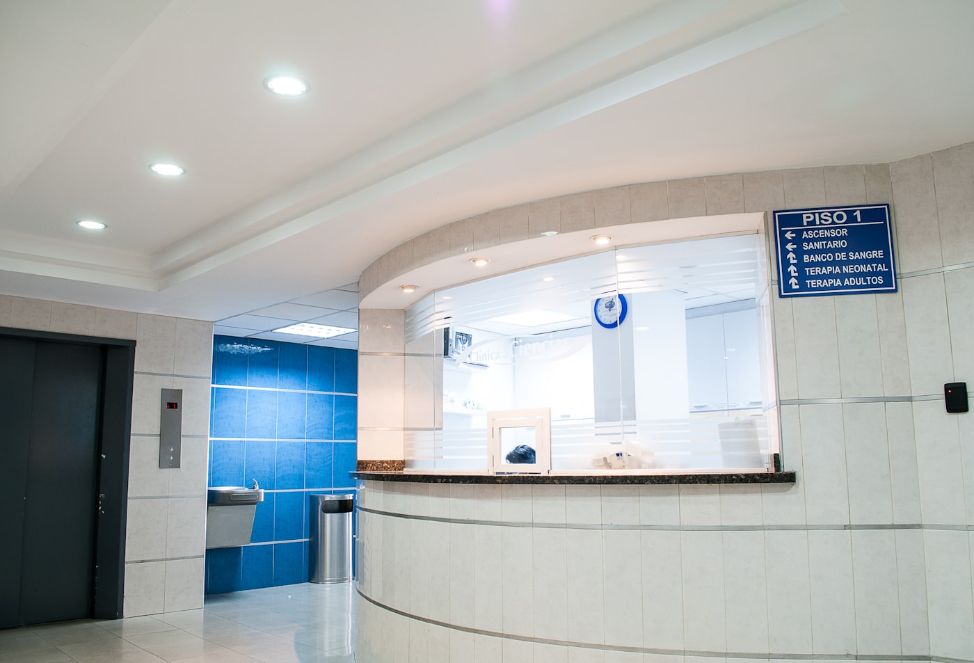 Clinic receptionist confirming a new patient booking at the front desk of a physiotherapy practice